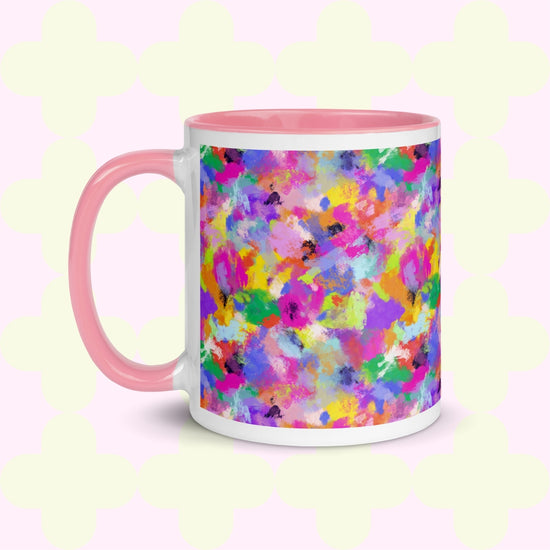 The Watercolour Rainbow Mug by My Favourite Colour is Rainbow features a pink handle and inner rim, displaying an abstract, vibrant design in shades of pink, purple, yellow, green, and blue.