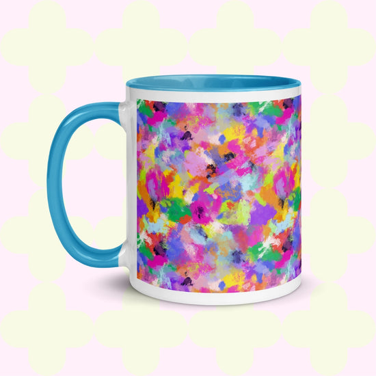 The Watercolour Rainbow Mug by My Favourite Colour is Rainbow features a vibrant abstract design with pink, blue, yellow, green, and purple splashes. It has a blue handle and interior .