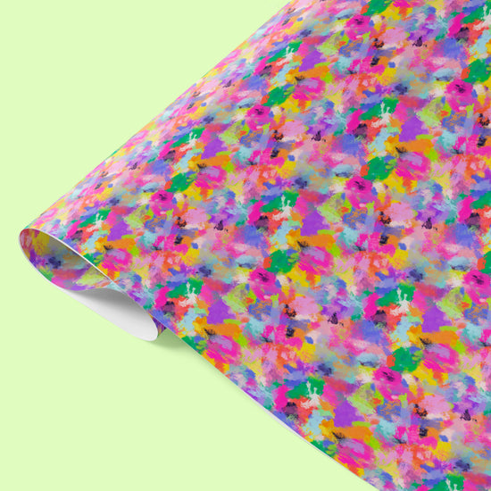 The Watercolour Rainbow Wrapping Paper Sheets by My Favourite Colour is Rainbow feature vibrant abstract splashes of colour in pink, orange, blue, green, and purple.  The wrapping paper is shown on a light green background.