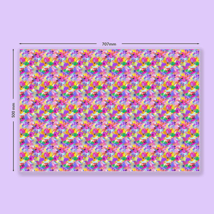 The Watercolour Rainbow Wrapping Paper Sheets by My Favourite Colour is Rainbow feature a colourful abstract pattern on recycled paper, measuring 707mm x 500mm, with vibrant tones of pink, purple, yellow, and green.  The wrapping paper is shown on a light purple background.