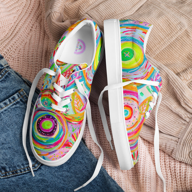 Summer Sorbet Canvas Sneakers by My Favourite Colour is Rainbow feature vibrant abstract circular patterns in green, pink, yellow, and blue on display with a comfortable fit next to a soft beige textured sweater and blue jeans.